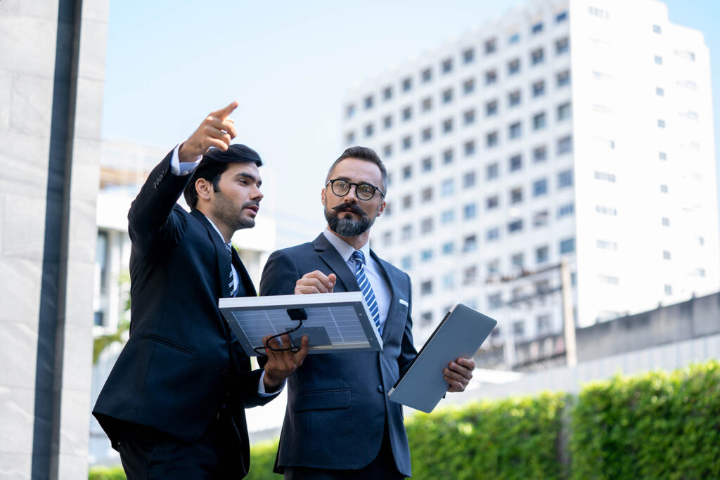 Two,Businessmen,Discuss,About,Renewable,Energy,Solar,Panels,On,Site